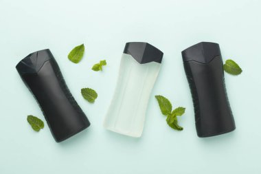 Erkekler, arka planda nane yapraklı kozmetik şişeleri, üst görünüm