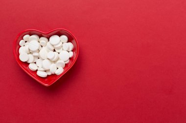 Kalp şeklindeki kase içindeki ilaçlar, arka plan, üst görünüm