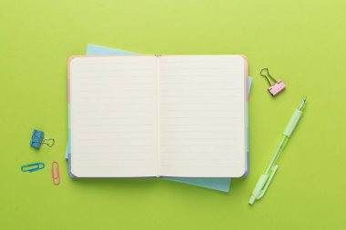 Renk arkaplanı ve üst görünümü üzerine kırtasiye içeren defter