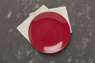 Beton zemin üzerinde masa örtüsü olan boş tabak, üst görünüm