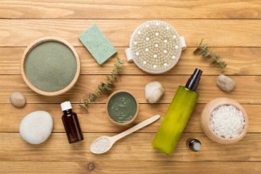 Ahşap arka planda kozmetik kil ve spa ürünleri ile kompozisyon, üst görünüm