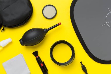 Renkli arka planda farklı kamera ekipmanları ve ürünler, üst görünüm