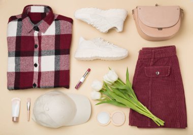 Renkli arka planda moda bahar kıyafetleri ve çiçeklerle yatıyordu