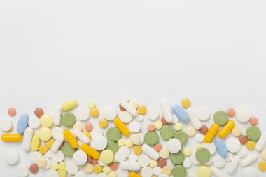 Farklı ilaç ve kapsüller. Renkli arka plan, üst görünüm.