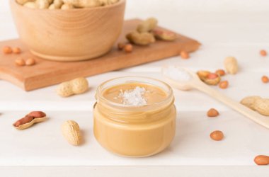 Ahşap arka planda fıstık ezmesi kavanozu.