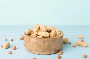 Ahşap masada soyulmuş ve soyulmamış fıstıklar.