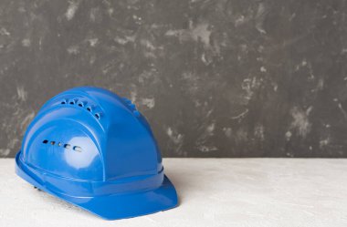 Beton arka planda mavi miğfer