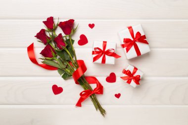 Ahşap arka planda hediye kutusu olan kırmızı gül çiçekleri, üst, manzara. Sevgililer Günü konsepti