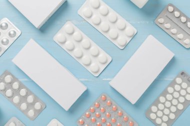 Su toplamada ve kutularda farklı haplar ve ahşap arka planda üst görünüm.