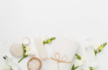 Renkli arka planda spa ürünleri ve çiçeklerle düz yatıyordu