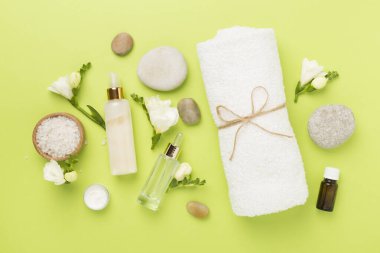 Renkli arka planda spa ürünleri ve çiçeklerle düz yatıyordu