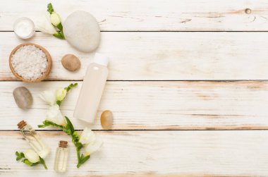 Tahta arka planda kaplıca ürünleri ve çiçeklerle yatıyordu