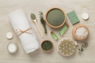 Ahşap arka planda kozmetik kil ve spa ürünleri ile kompozisyon, üst görünüm