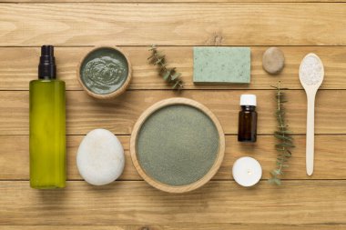 Ahşap arka planda kozmetik kil ve spa ürünleri ile kompozisyon, üst görünüm