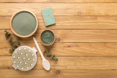 Ahşap arka planda kozmetik kil ve spa ürünleri ile kompozisyon, üst görünüm