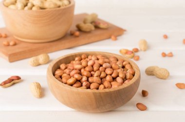 Ahşap masada soyulmuş ve soyulmamış fıstıklar.