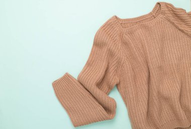 Renkli arka planda bej örülmüş süveter, üst görünüm