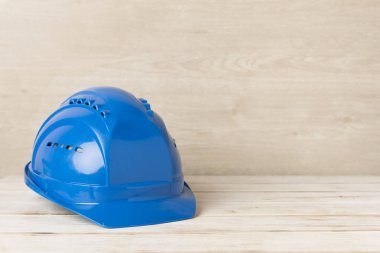 Ahşap masada mavi miğfer