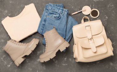 Beton arka planda modaya uygun bahar kıyafetleriyle yatıyordu.