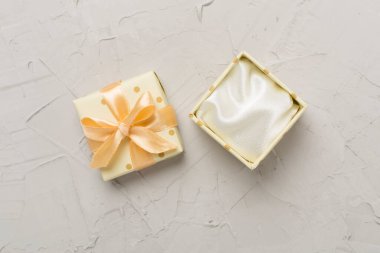 Beton zemin üzerinde bej rengi açık hediye kutusu, üst görünüm