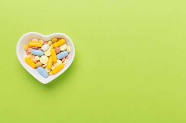 Kalp şeklindeki kase içindeki ilaçlar, arka plan, üst görünüm