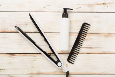 Tahta arka planda termo korumalı saç düzleştirici, üst, görünüm