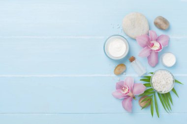 Orkideli kompozisyon, ahşap arka planda spa ürünleri, üst görünüm