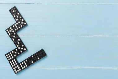 Ahşap zemin üzerinde siyah domino taşları, üst görünüm