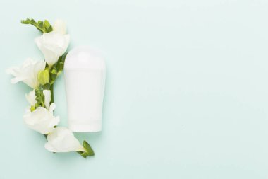 Renkli arka planda frezya çiçekleri olan kozmetik şişesi, üst görünüm