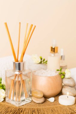 Tahta masa üzerinde frezya çiçeği ve aroma yayıcı içeren spa kompozisyonu