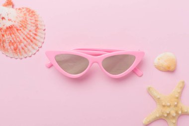 Renkli arka planda pembe güneş gözlüğü, üst manzara. Yaz konsepti