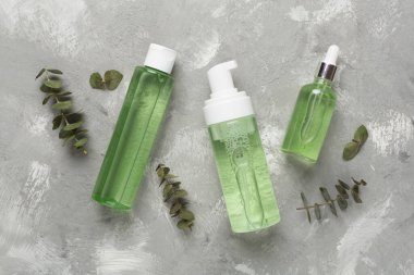 Beton arka planda bitkisel yüz bakım ürünleri, üst görünüm