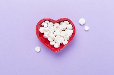 Kalp şeklindeki kase içindeki ilaçlar, arka plan, üst görünüm