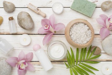 Orkideli kompozisyon, ahşap arka planda spa ürünleri, üst görünüm