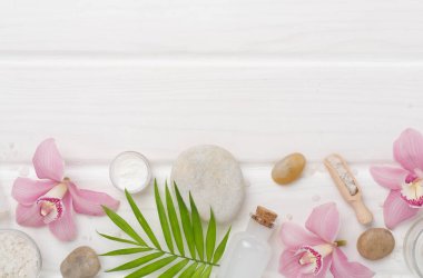 Orkideli kompozisyon, ahşap arka planda spa ürünleri, üst görünüm