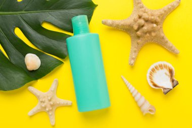 Renk arkaplanında yaz dekoru olan güneş kremi, üst görünüm