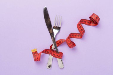 Arka planda çatal ve bıçakla mezuranın ölçüsü, üst, görüş. Kilo kaybı konsepti