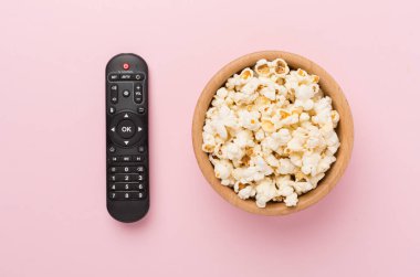 Patlamış mısır ve televizyon uzaktan kumandası renk arkaplanında