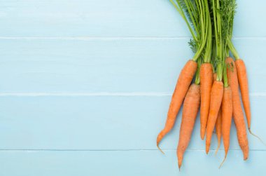 Ahşap zemin üzerinde taze havuç demeti, üst görünüm