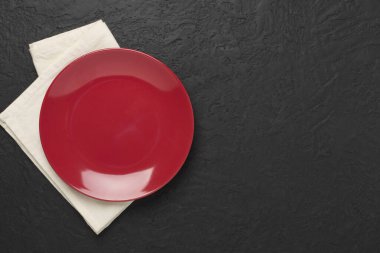 Beton zemin üzerinde masa örtüsü olan boş tabak, üst görünüm