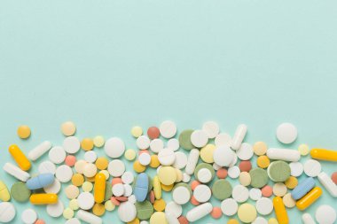 Farklı ilaç ve kapsüller. Renkli arka plan, üst görünüm.