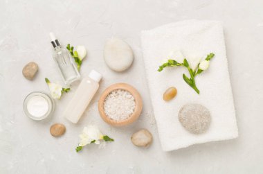 Tahta arka planda kaplıca ürünleri ve çiçeklerle yatıyordu