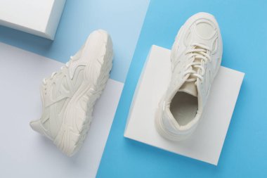 Renkli arka planda beyaz kadın moda spor ayakkabıları, üst görünüm