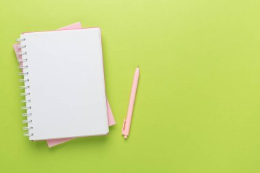 Renk arkaplanı ve üst görünümü üzerine kırtasiye içeren defter