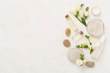 Tahta arka planda kaplıca ürünleri ve çiçeklerle yatıyordu