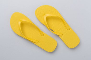 Renkli arka planda parlak sarı parmak arası terlikler, üst manzara. Yaz konsepti