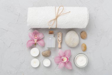 Beton zemin üzerinde orkideler ve masaj taşları olan kompozisyon, üst görünüm