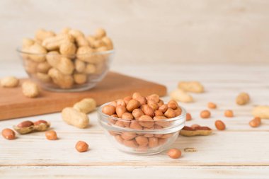 Ahşap masada soyulmuş ve soyulmamış fıstıklar.