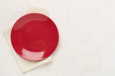 Beton zemin üzerinde masa örtüsü olan boş tabak, üst görünüm