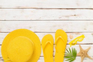 Tahta arka planda sarı yazlık kıyafetlerle yatıyordu. Tatil kavramı